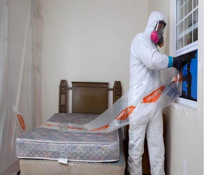 SERVPRO technician setting up containment in a bedroom